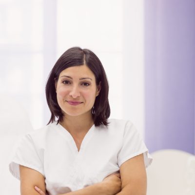 Portrait of female dermatologist standing with arms crossed in clinic